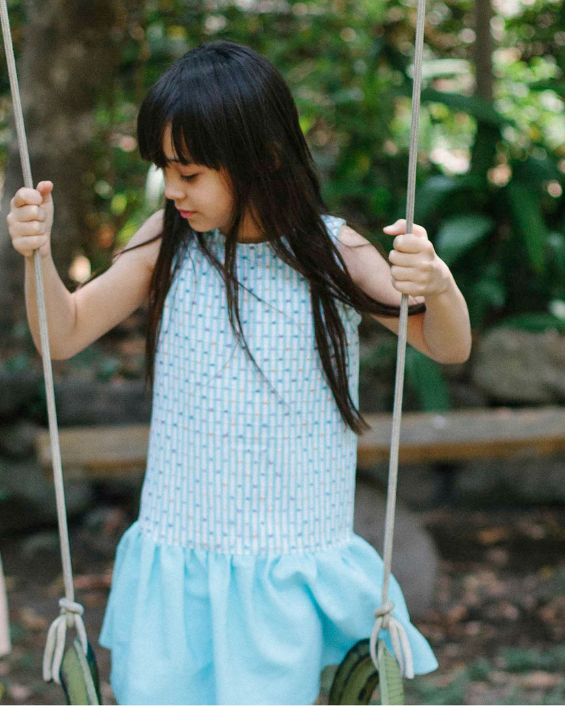 Girl wearing a blue polka dot and stripe handwoven dress