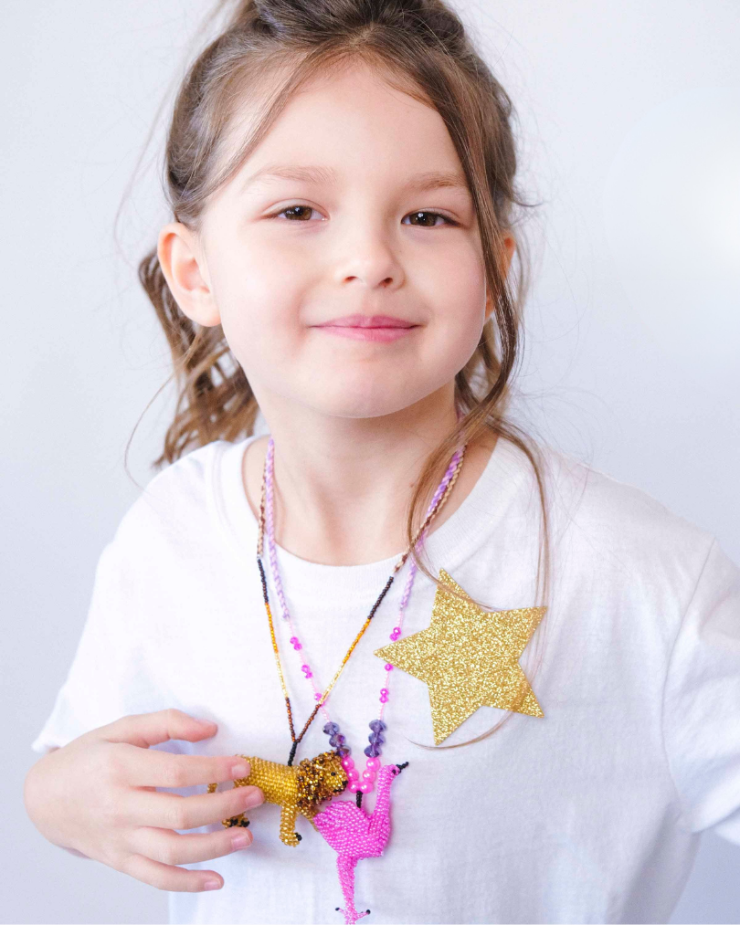 girl wearing a lion and flamingo necklace